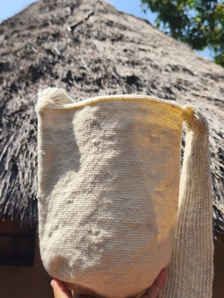 Mochila artesanal kankuama elaborada en lana de oveja frente a un kankurúa
